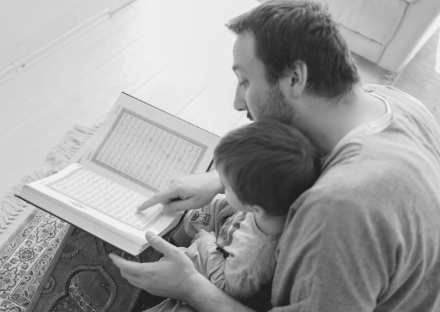Un homme lit l'histoire du Coran à un enfant