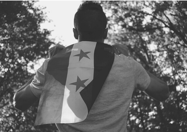 Musulman non sunnite brandissant un drapeau syrien